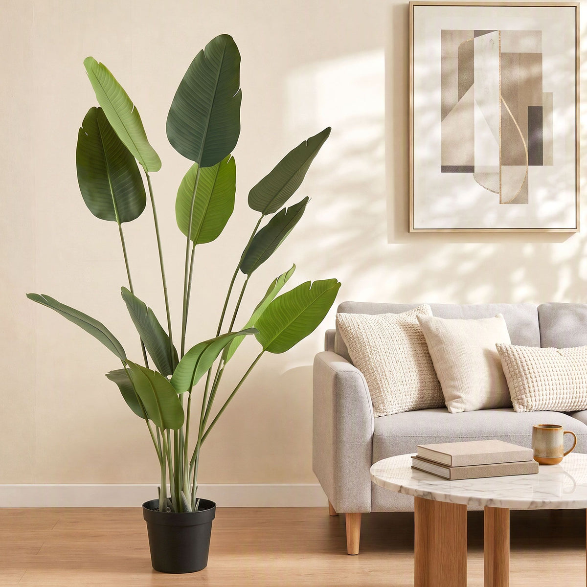 Artificial bird of paradise plant with green textured leaves in a black pot