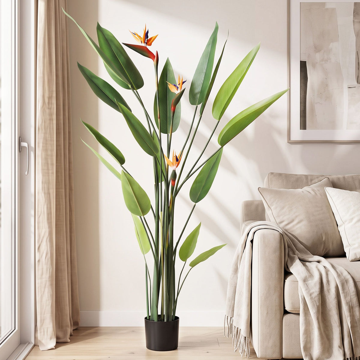 Artificial bird of paradise plant with green leaves and orange-blue flowers in black pot