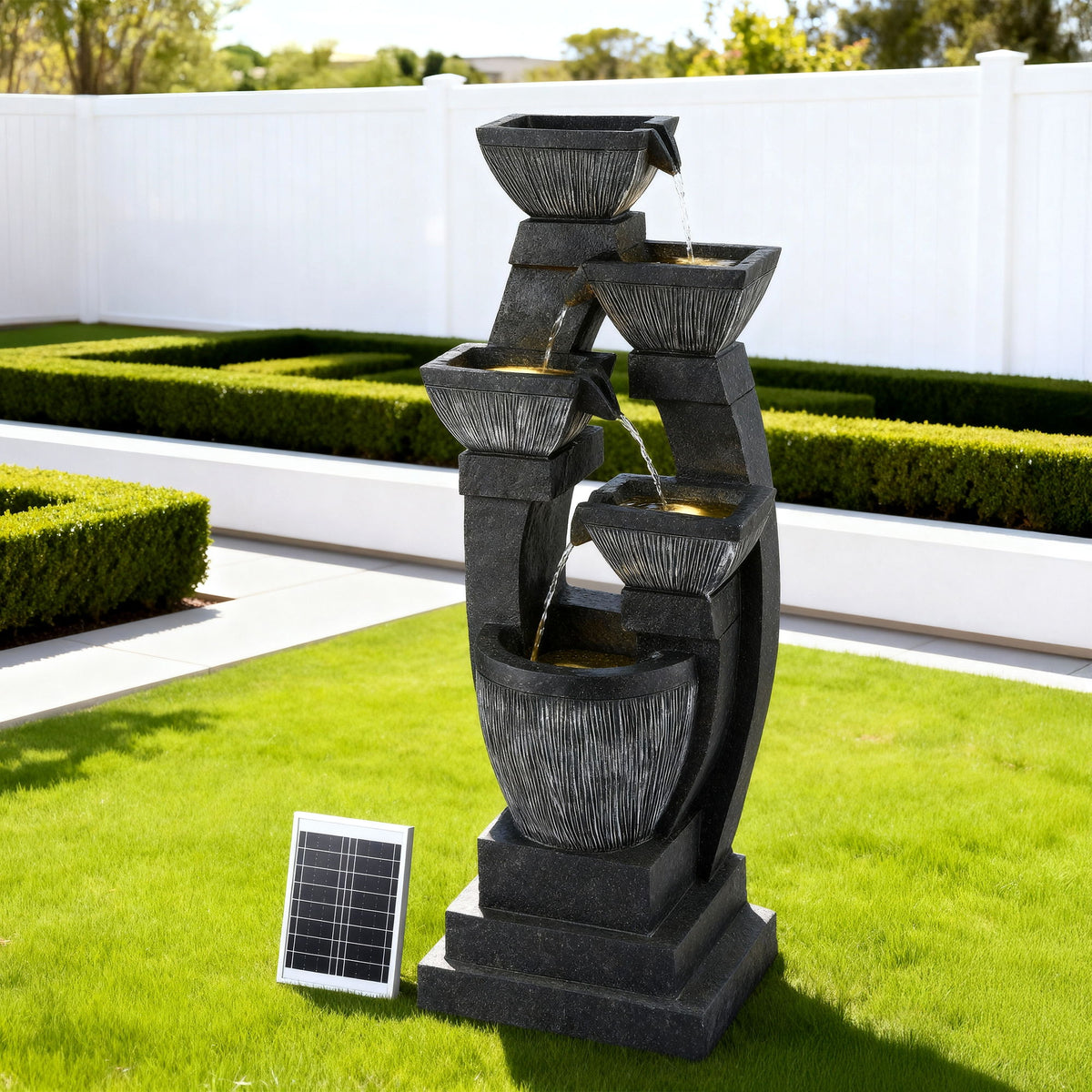 Outdoor tiered water fountain with solar panel on a grassy area