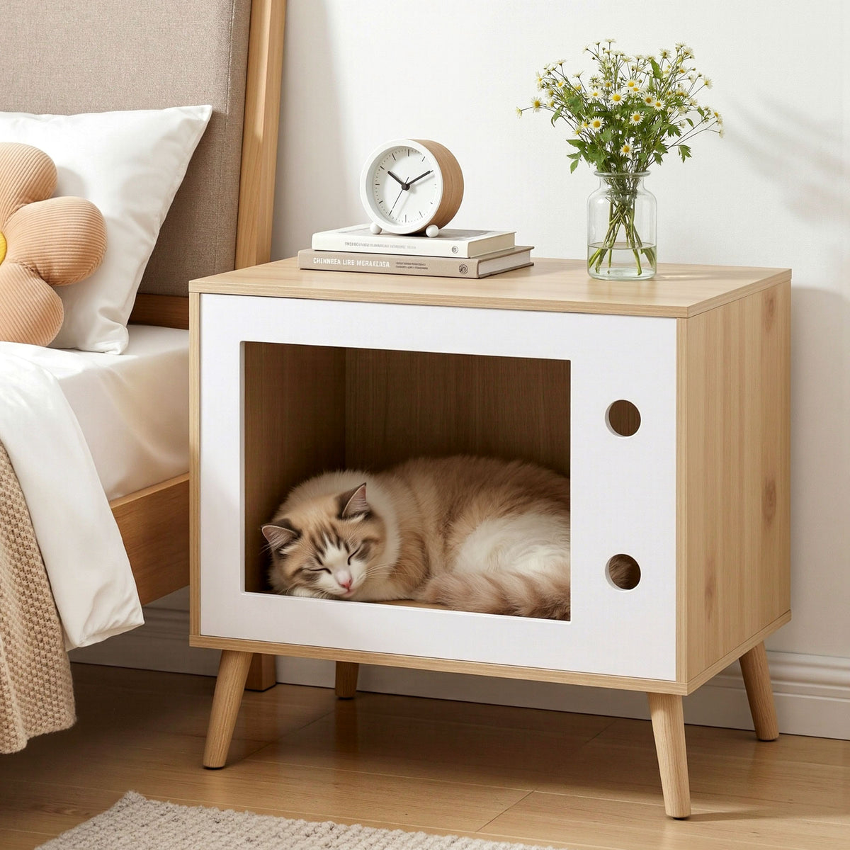 Light wood cat bedside table with white cabinet and open window, cat resting inside