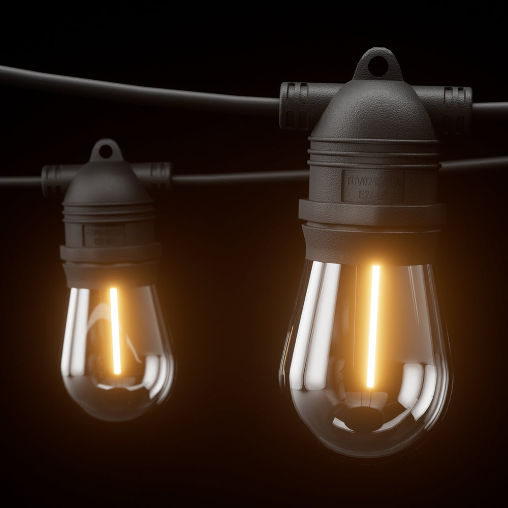 Warm-lit vintage bulb string lights with clear glass bulbs and black weatherproof sockets