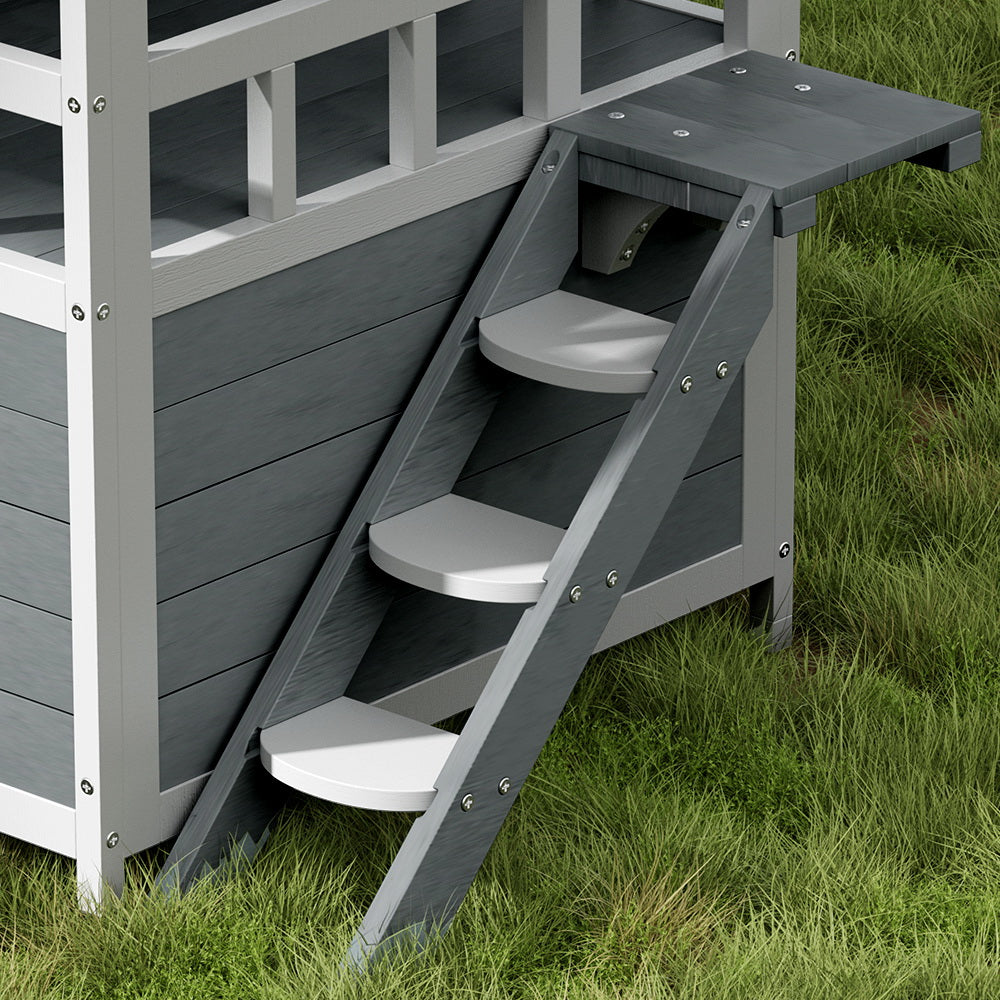 Grey ramp stairs and enclosed side door on a white outdoor cat house