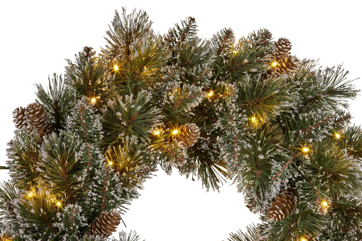 Close-up of Christmas pine wreath with warm LED lights and pinecones
