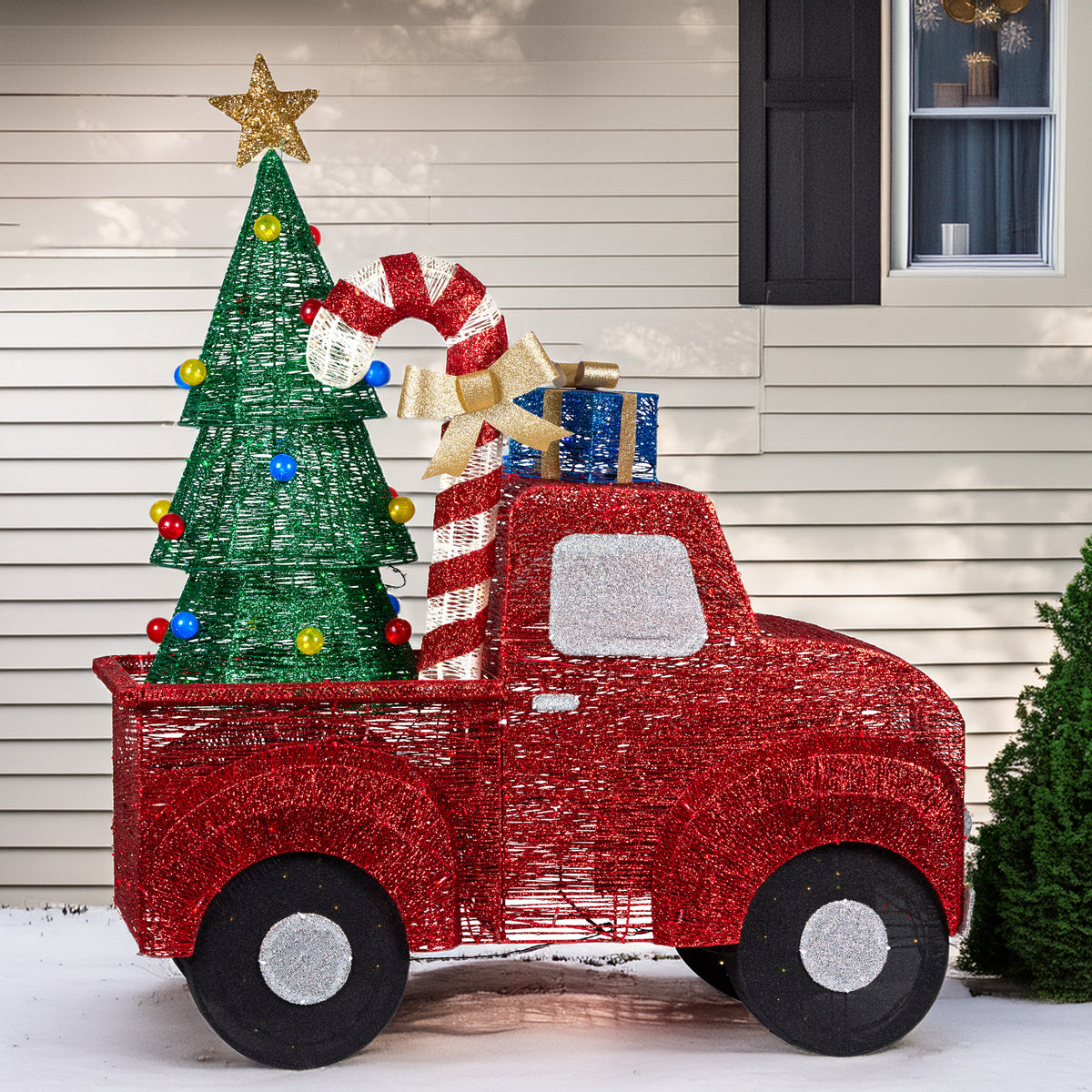 Outdoor Christmas LED truck with green tree, red truck body, gold star topper, and multicolor bulbs