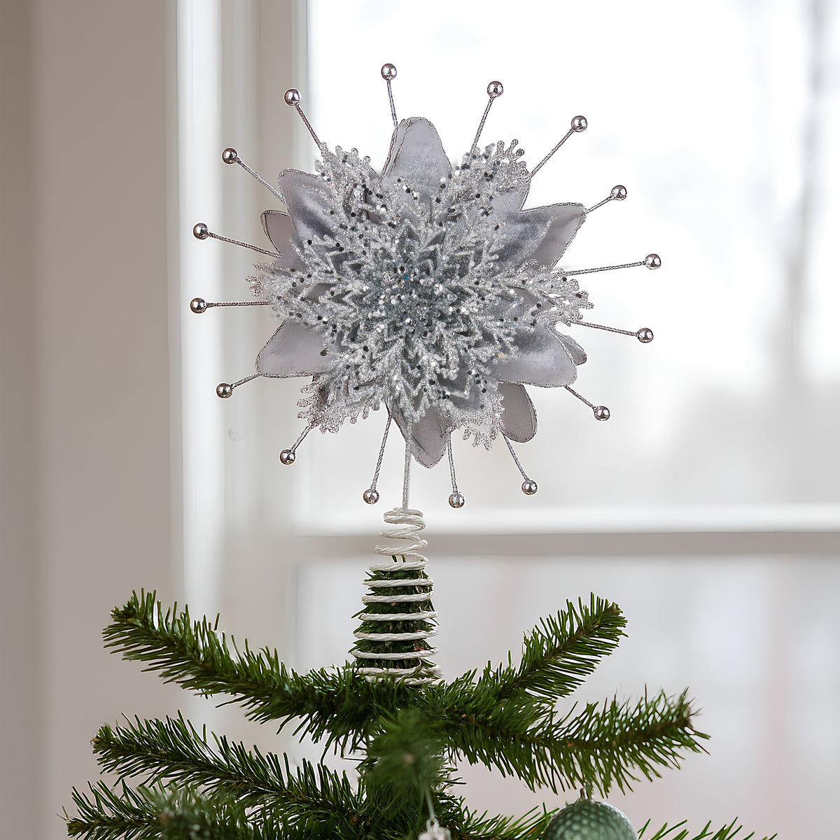 Silver poinsettia Christmas tree topper with layered glitter petals and wire tips