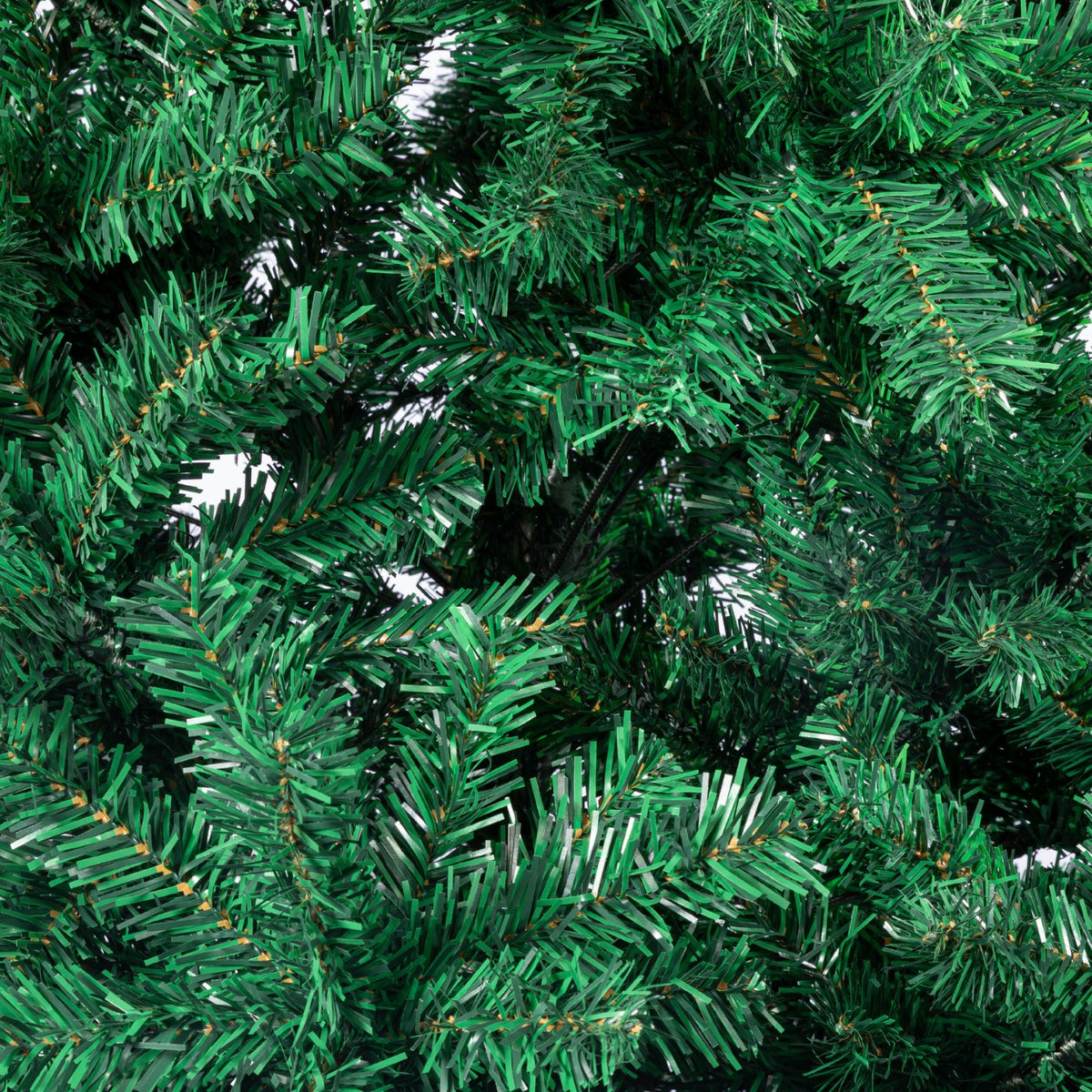 Close-up of green artificial Christmas tree tips with dense needle-like branches