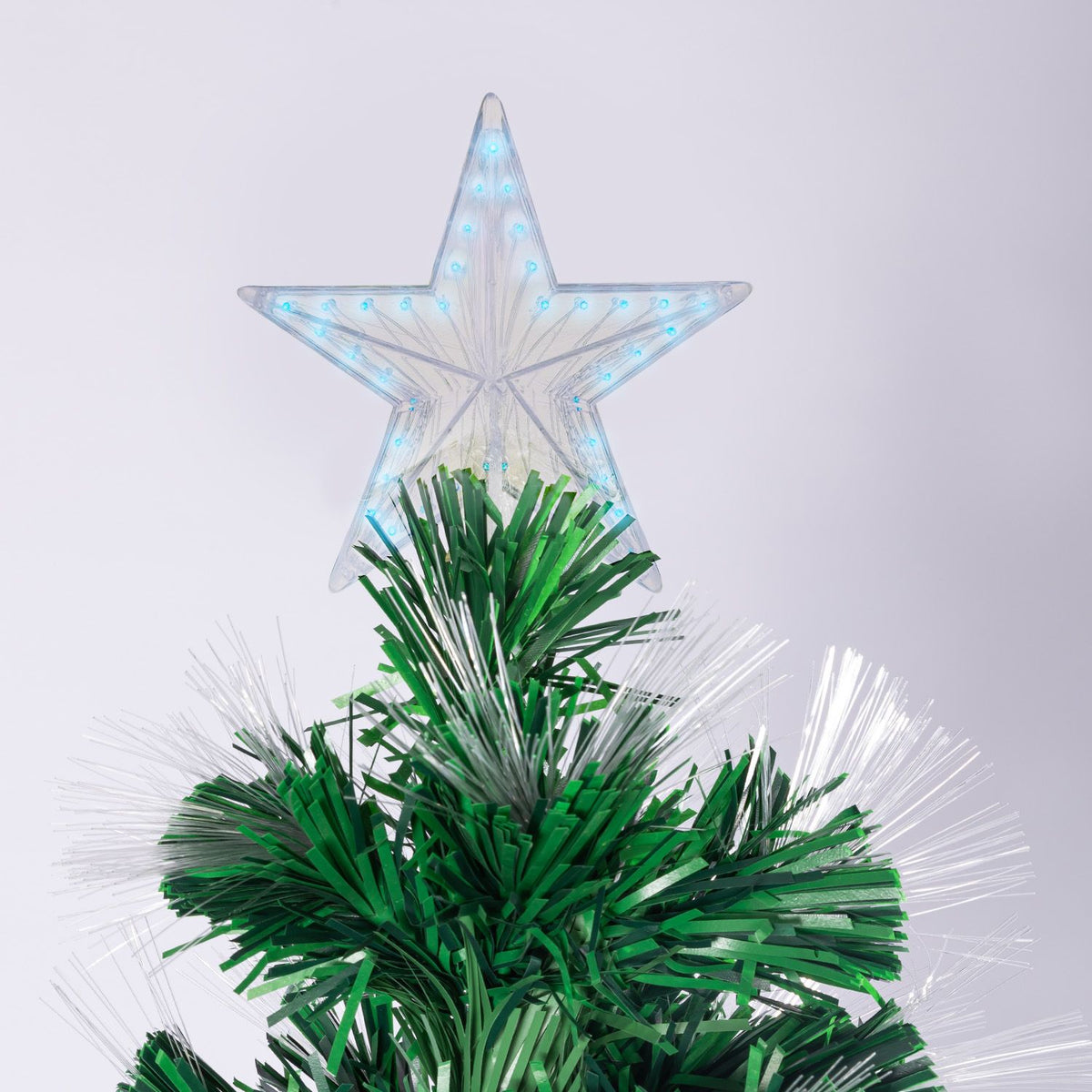 Star-shaped light topper with blue glow on artificial Christmas tree needles