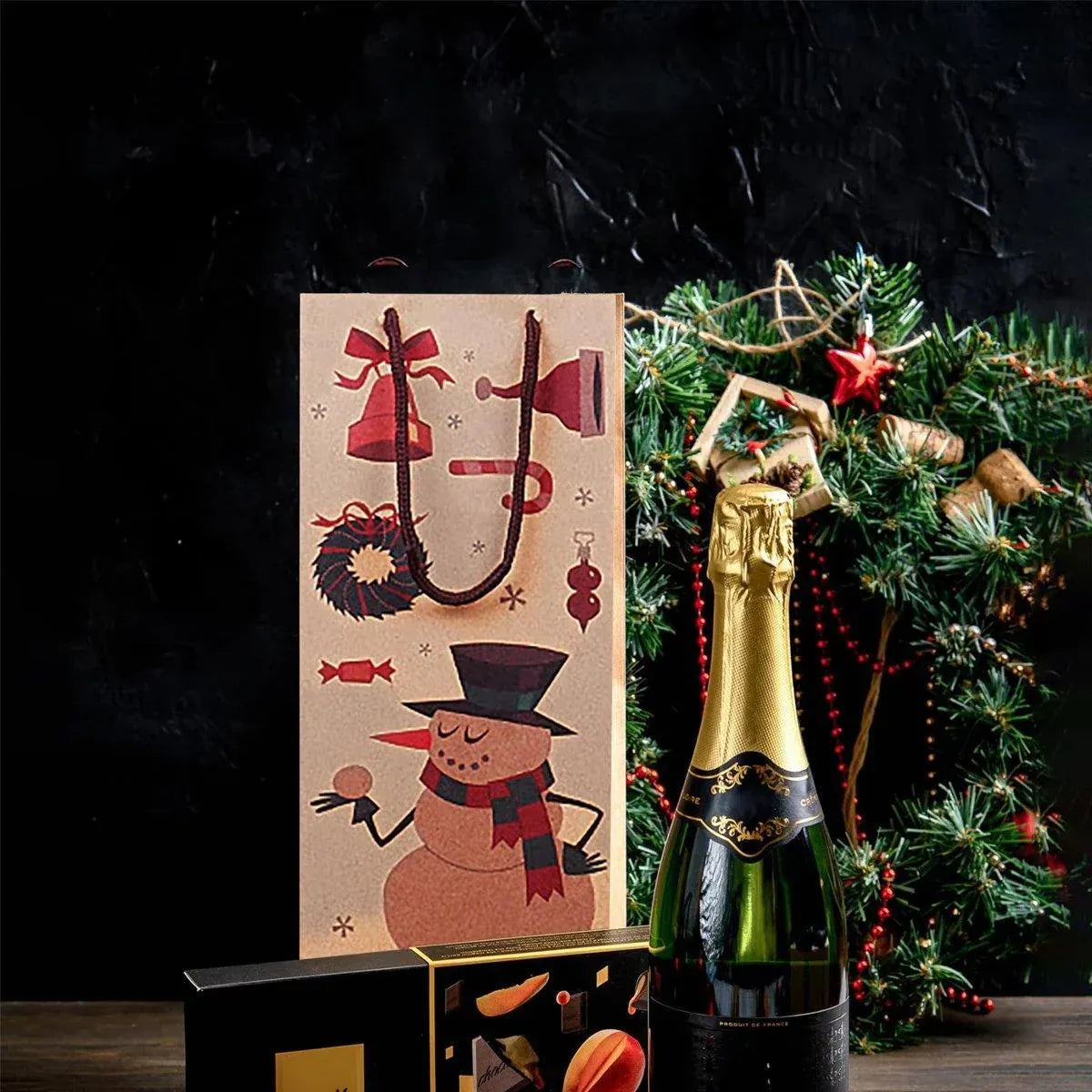 Kraft wine bottle gift bag with snowman figure design beside a champagne bottle