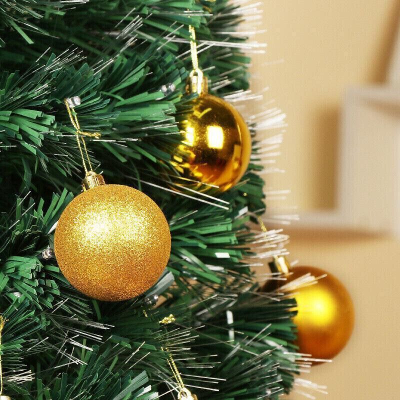 Gold glitter and gold shiny Christmas tree bauble ornaments hanging from a tree
