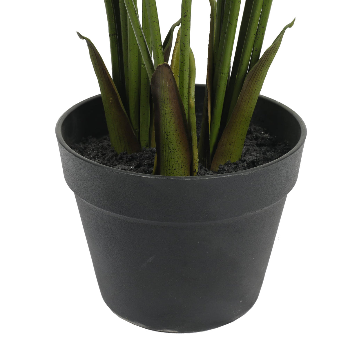 Artificial palm fronds and dark green stems in a black round pot with soil