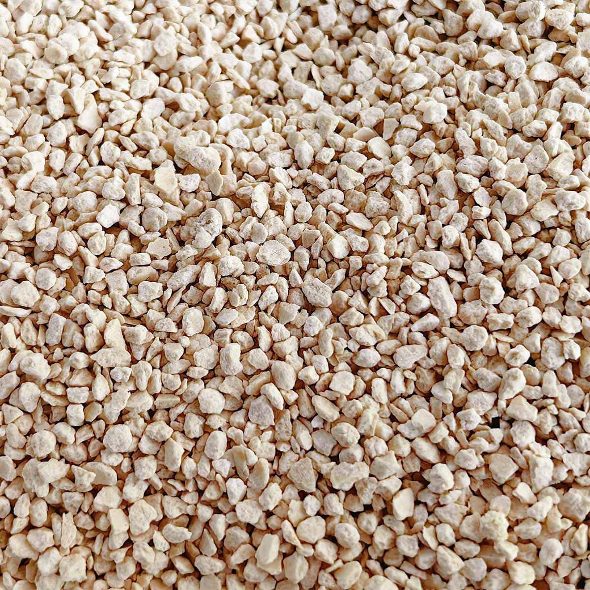 Bamboo cat litter pellets, light tan clumps in close-up.