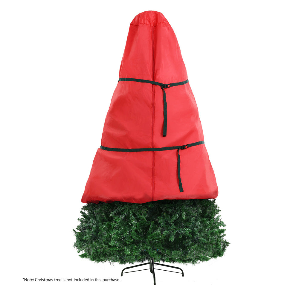 Red storage bag covering a green artificial Christmas tree on a stand