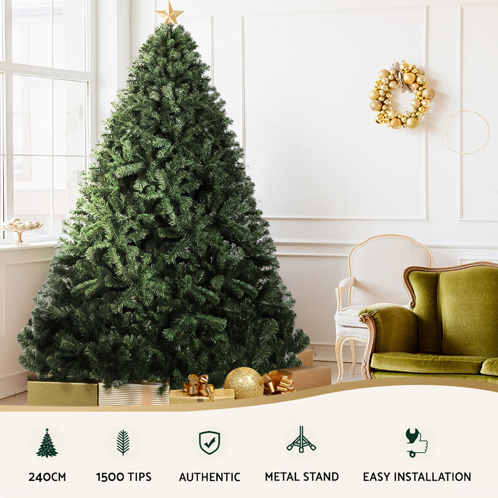 Decorative Christmas tree in a living room with a green sofa and gold wreath.