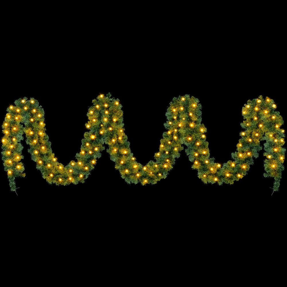 Pre-lit Christmas garland with warm yellow LED lights on green pine tips