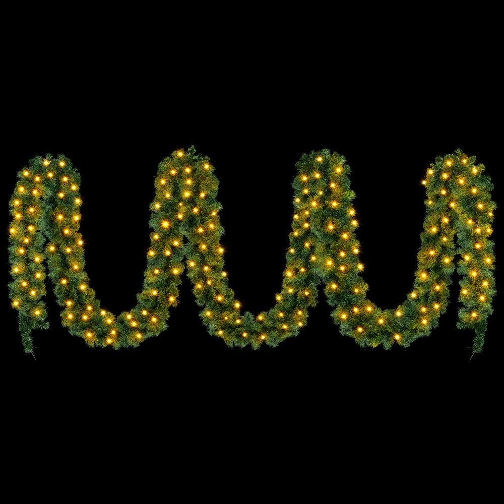 Green pre-lit Christmas garland strand shaped like a W, with warm yellow LED lights