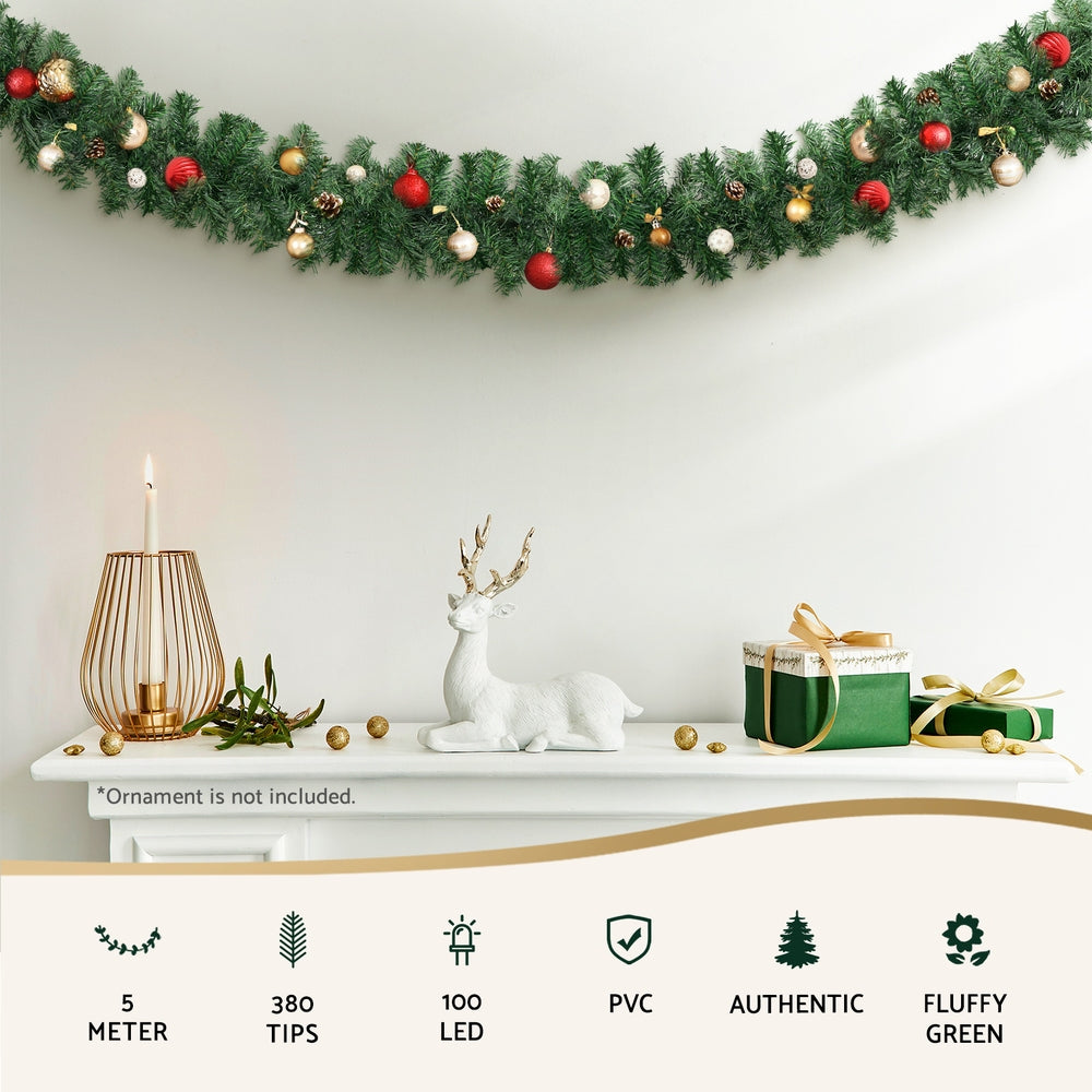 Green pre-lit Christmas garland with warm LED lights and red-and-gold ornament balls