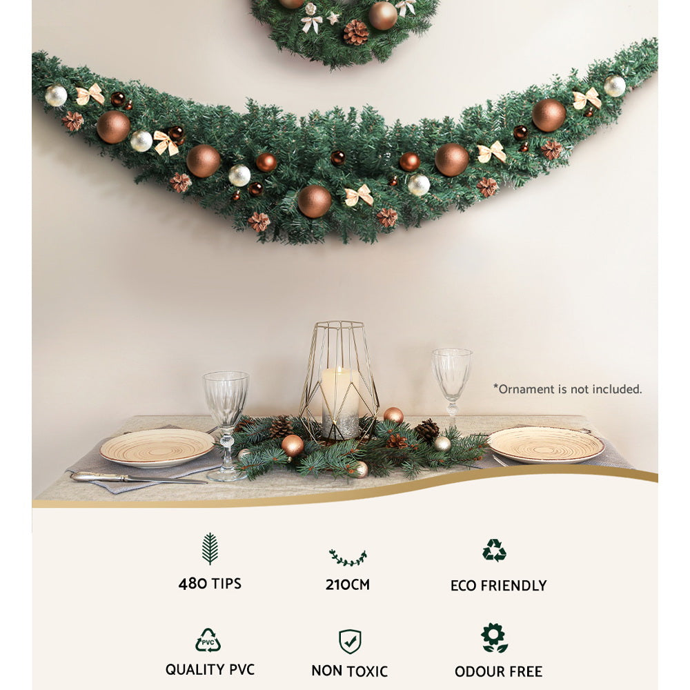 Decorated green Christmas garland with pine tips, gold and white baubles, bows