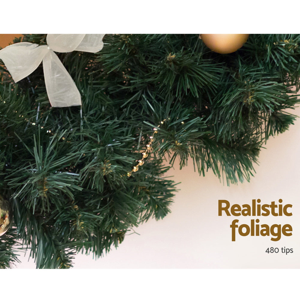 Green Christmas garland with pine branches and a white bow decoration