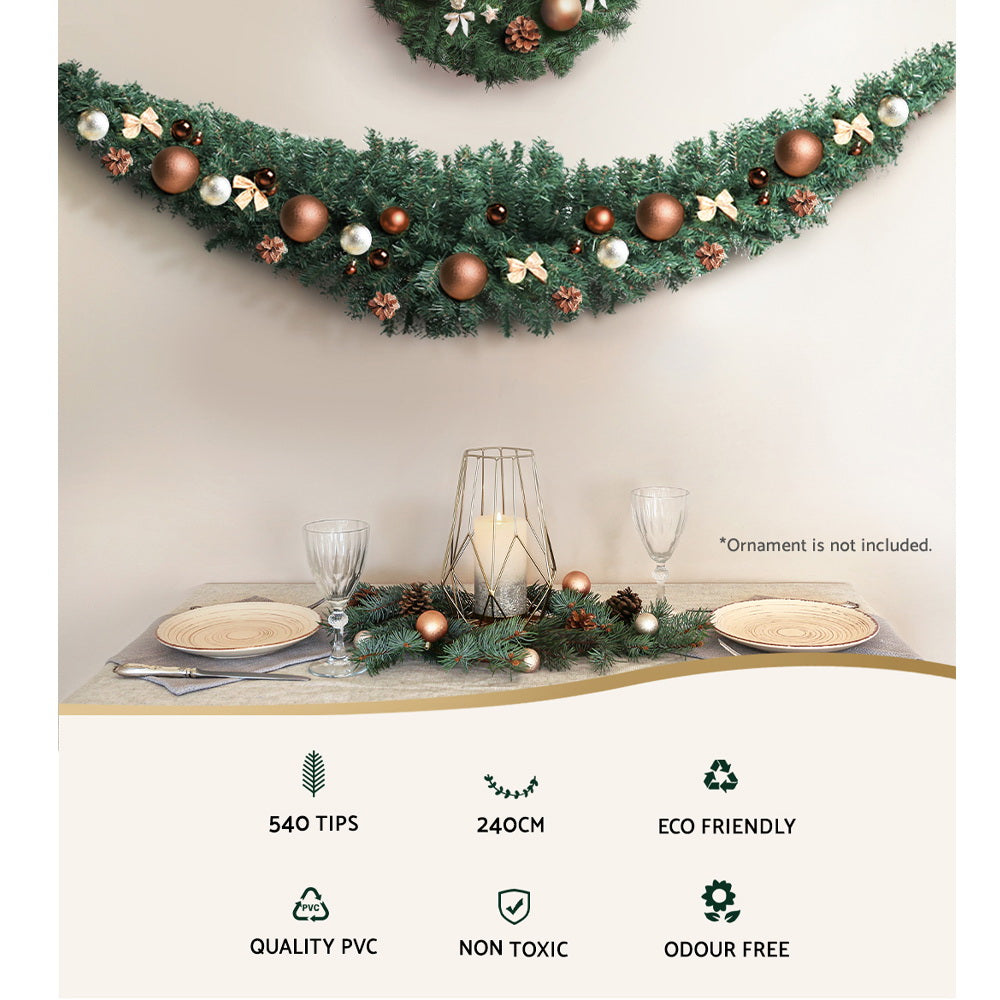 Green Christmas garland with pine tips, brown baubles, and small bows