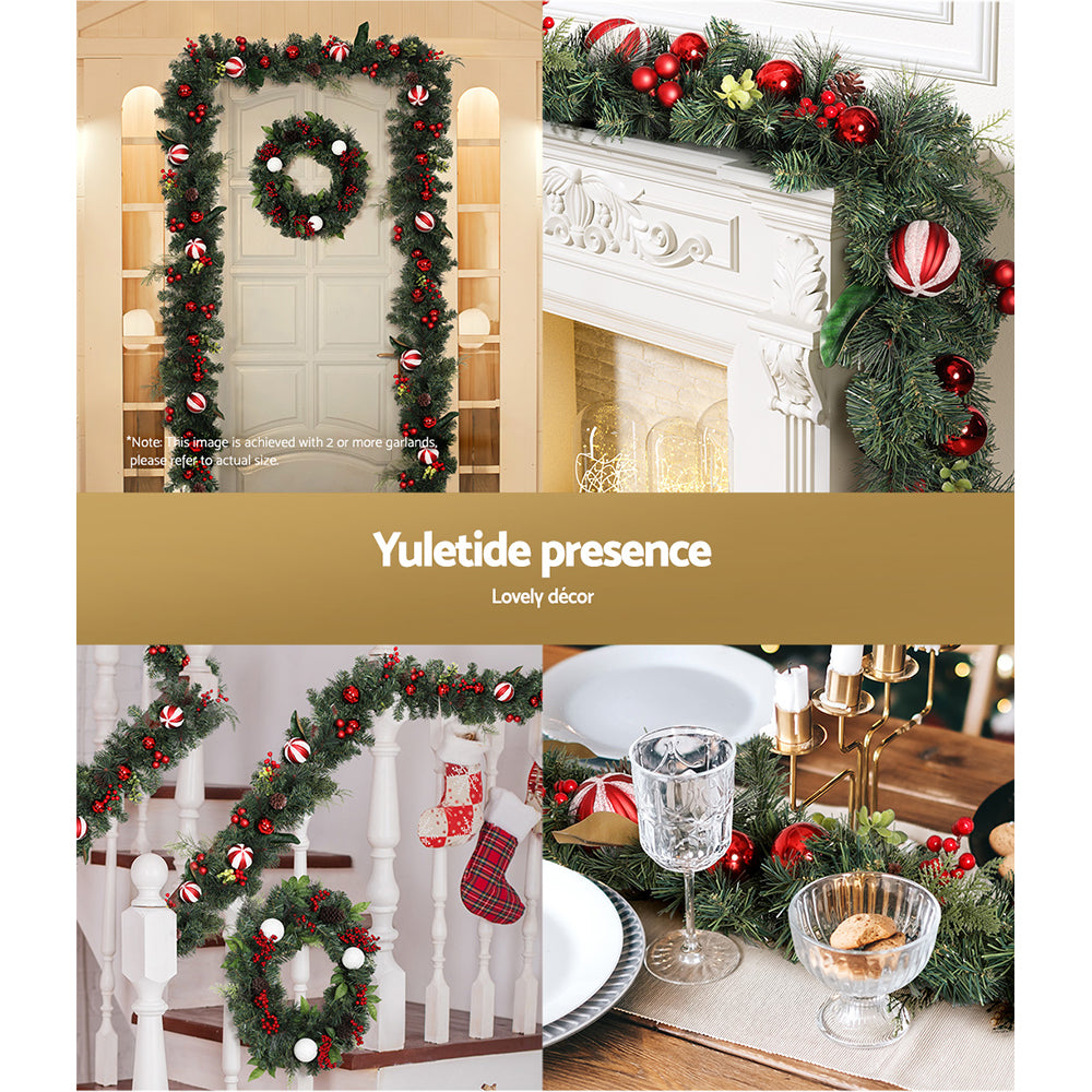 Christmas garland with dark green pine, red ornaments, and striped ribbon balls over mantel