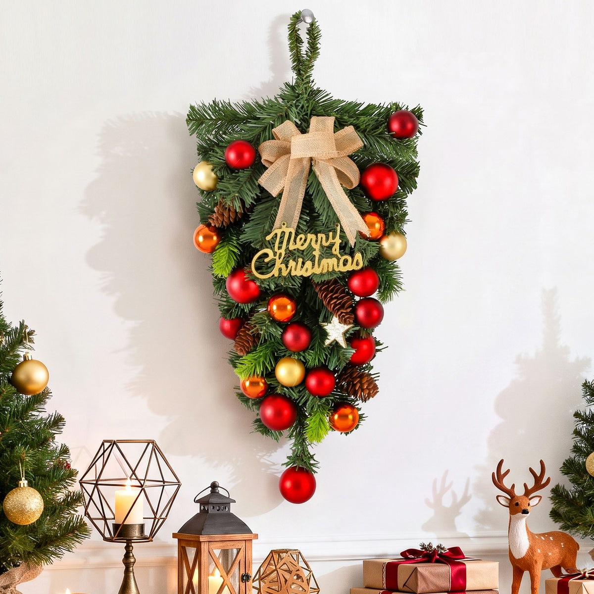Hanging Christmas garland wreath with pinecones, red and gold baubles, beige bow, star
