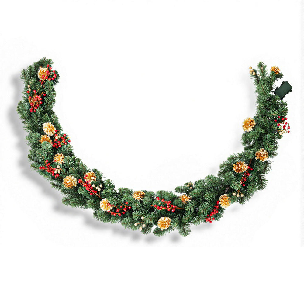 Christmas garland of pine greenery with gold pine cones and red berries