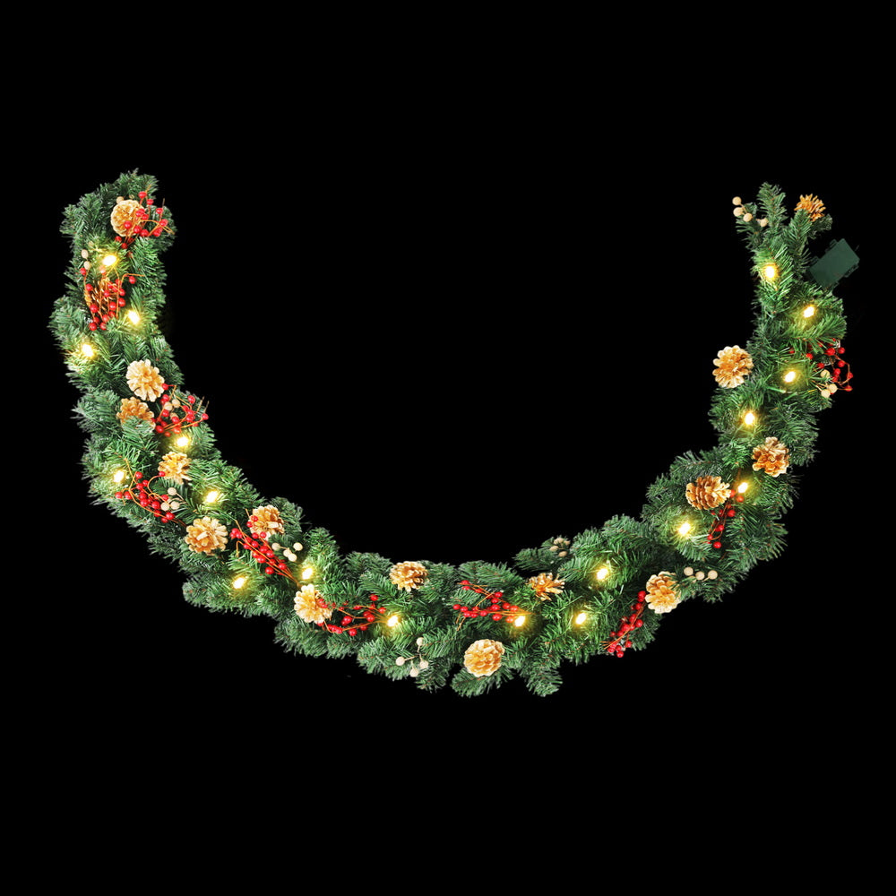 Pre-lit Christmas garland with warm LEDs, pinecones, and red berry accents