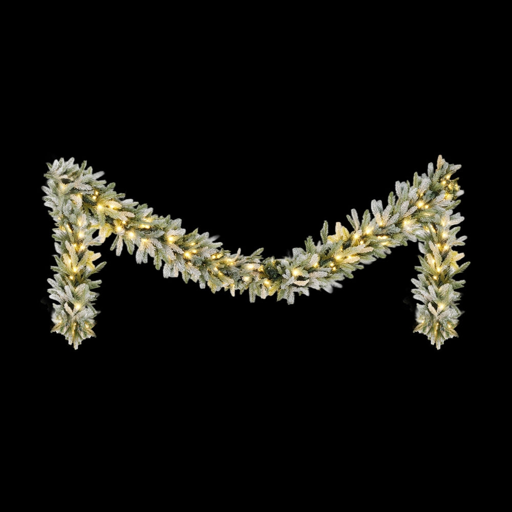 Frosted pine garland with warm white LED lights and snow-dusted branch tips