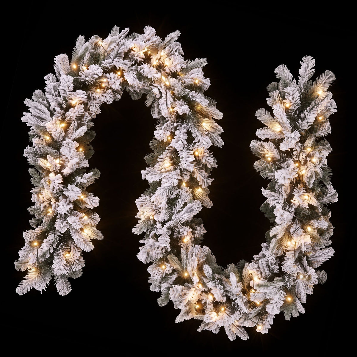 Frosted Christmas garland with warm white LED lights, close-up wreath form