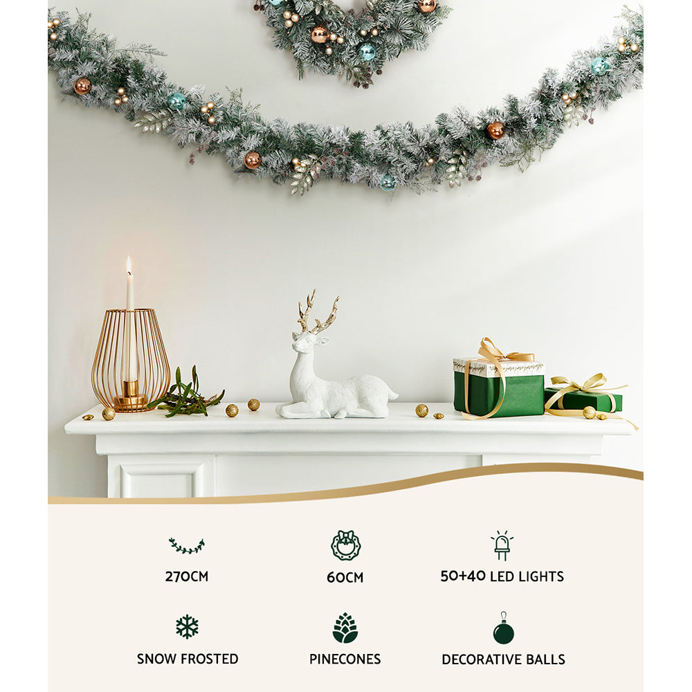Frosted Christmas garland with LED lights and teal, gold, and bronze decorative balls