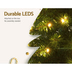 Artificial Christmas tree branch with warm LED bulbs embedded in green needles