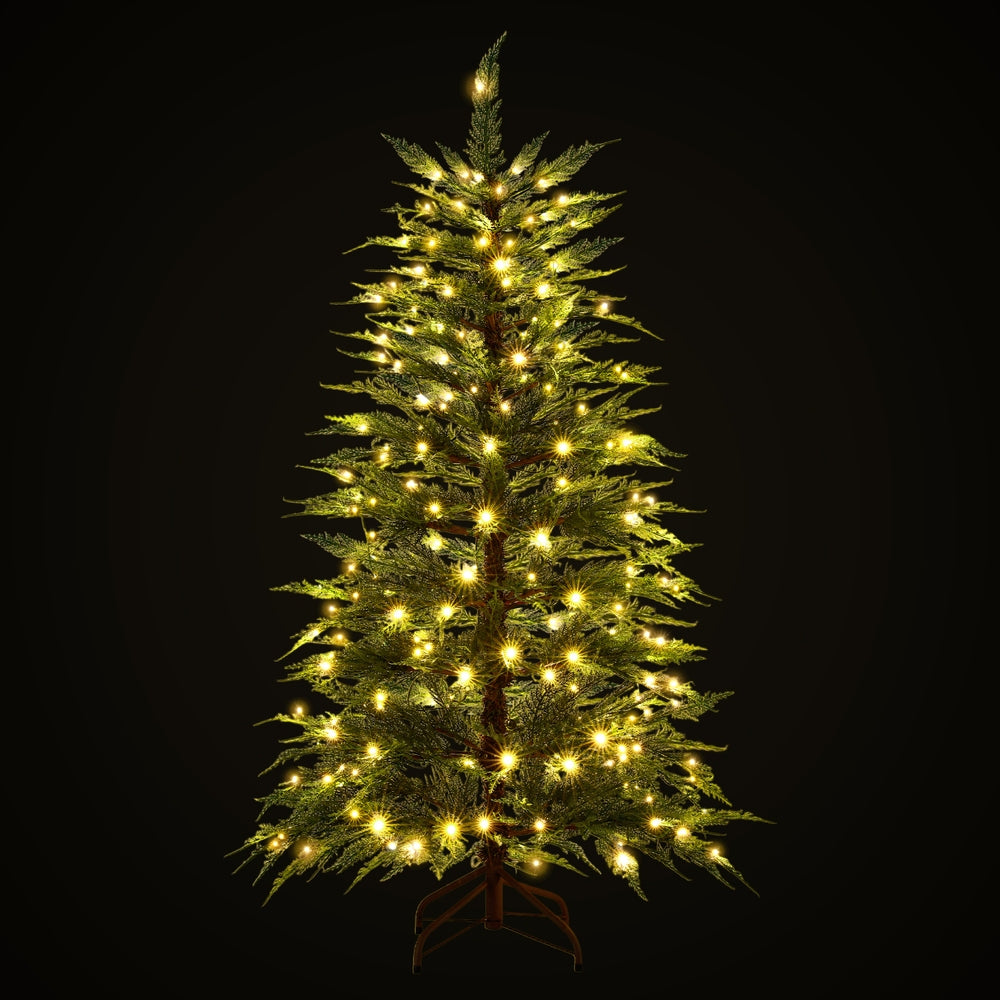 Pre-lit sparse Christmas tree with warm white LED lights, full-lit view, metal stand
