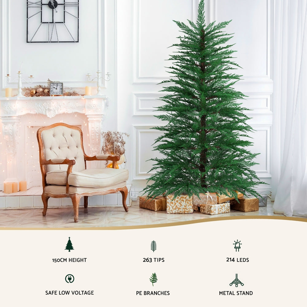 Pre-lit sparse Christmas tree with warm white LED lights, standing on metal stand