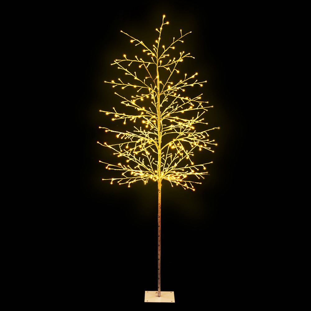 Warm-white LED jingle tree with slender trunk and lit branch tips, on a stand base