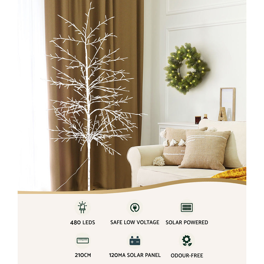 Warm-white LED jingle tree indoors, with feature icons displayed at the bottom