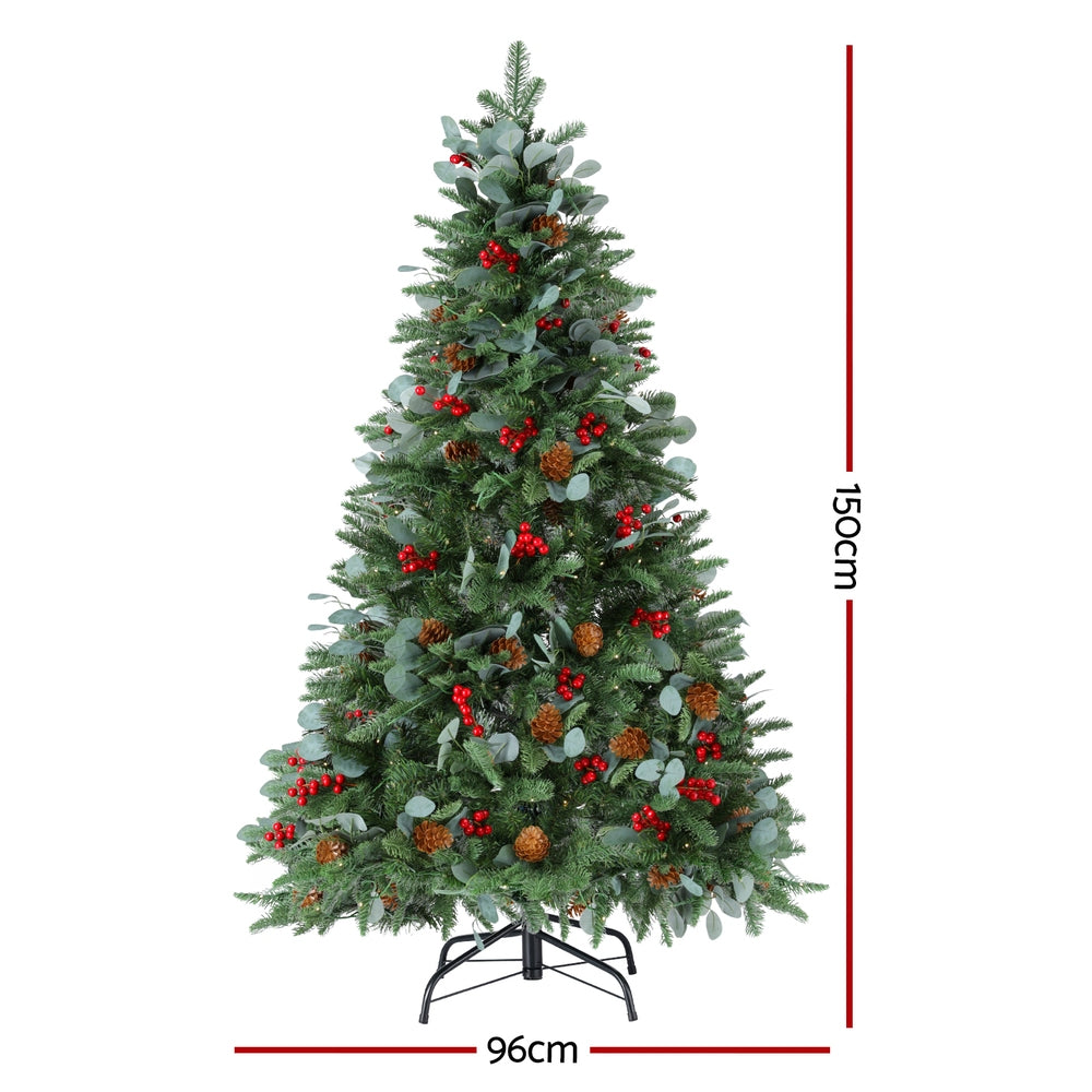 Pre-lit artificial Christmas tree with warm lights, red berries, pinecones, and dense tips