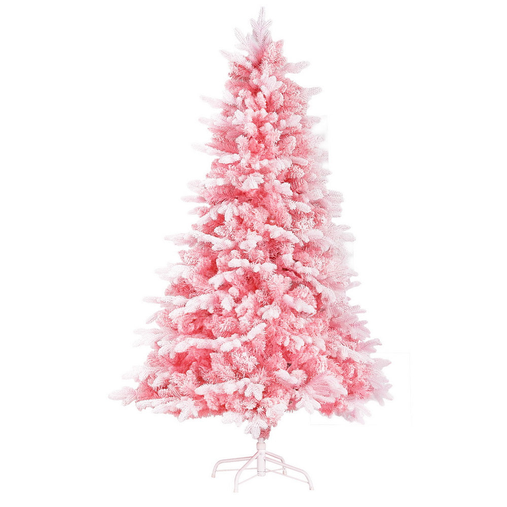 Pink snowy artificial Christmas tree with full, fluffy tiered branches