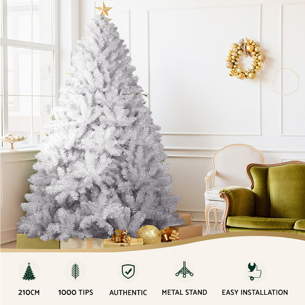 Artificial white Christmas tree with dense white tips, displayed indoors on a stand.