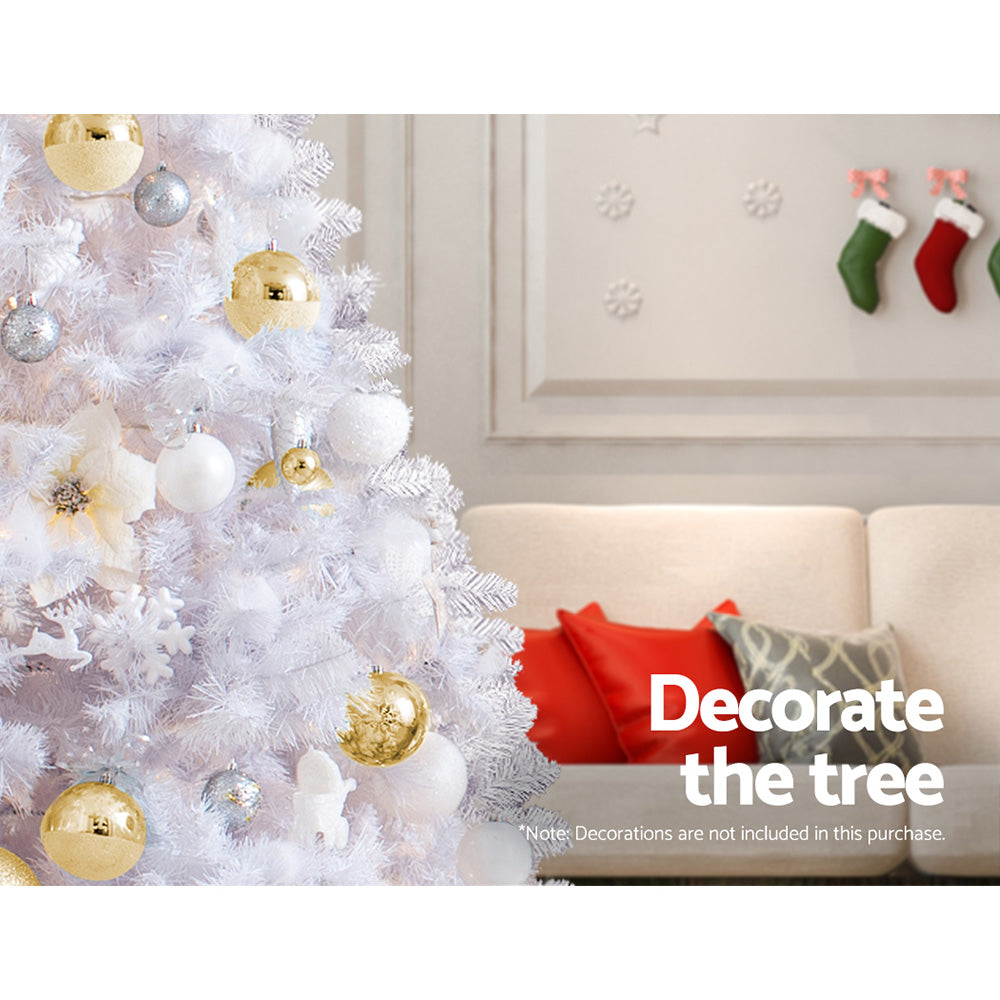 Decorated white Christmas tree with gold and white baubles and ribbon garland.