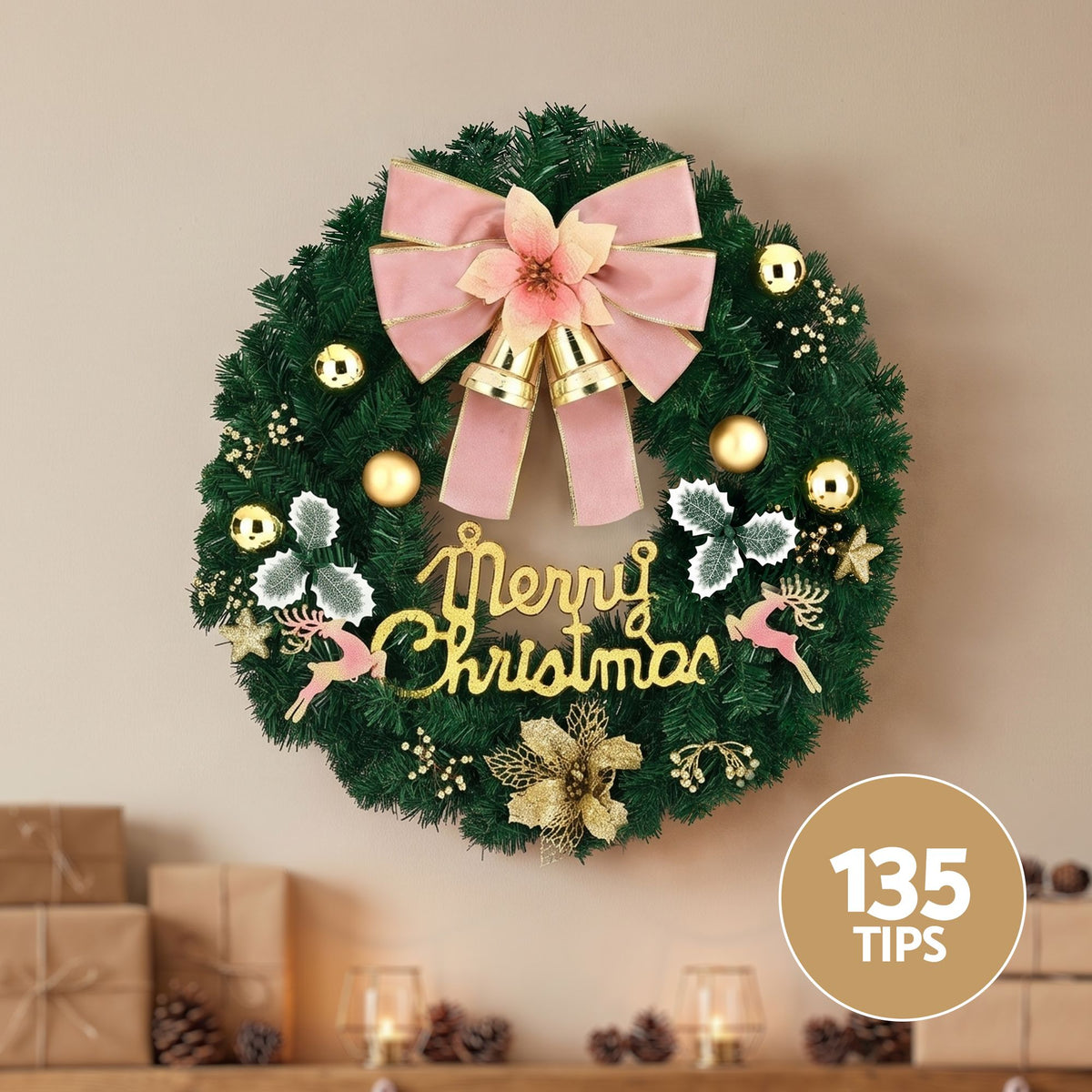 Christmas wreath with pink bow, gold baubles and bells, and Merry Christmas sign