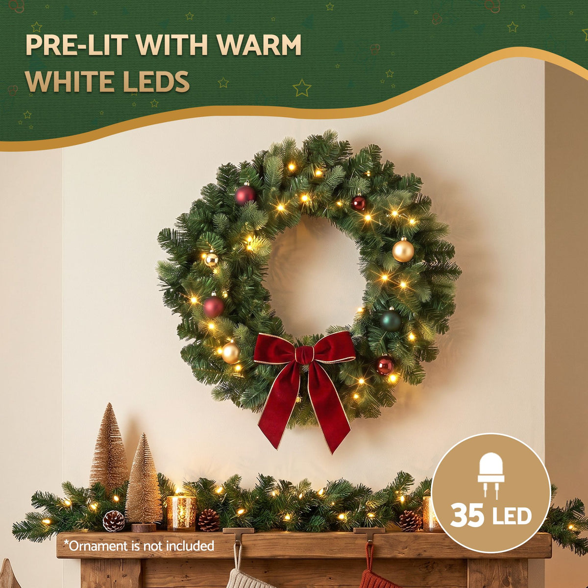 Pre-lit Christmas wreath with warm white LED lights, red bow, and hanging ornament balls