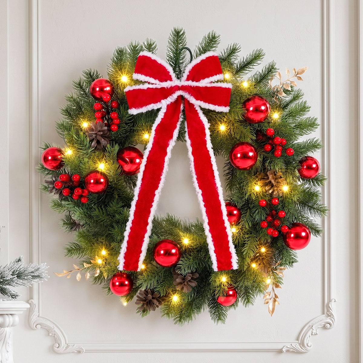 Pre-lit Christmas wreath with red ribbon bow, red ornaments, pinecones, warm LED lights on door