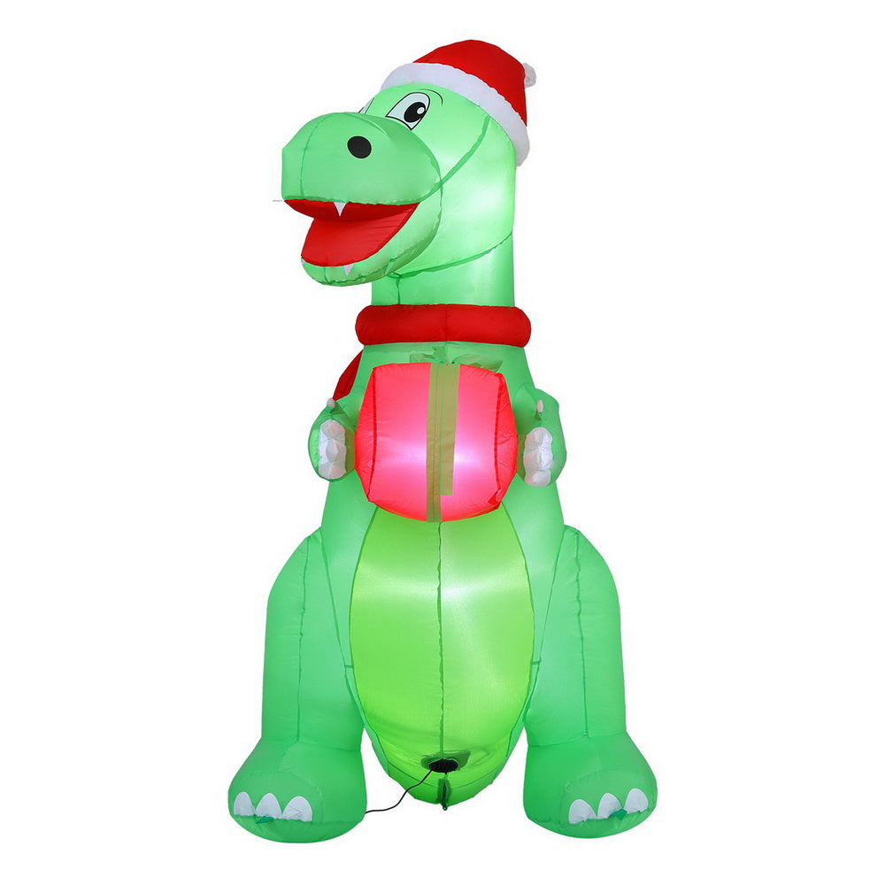 Inflatable green dinosaur with red scarf and Santa hat, LED glow, holding pink gift