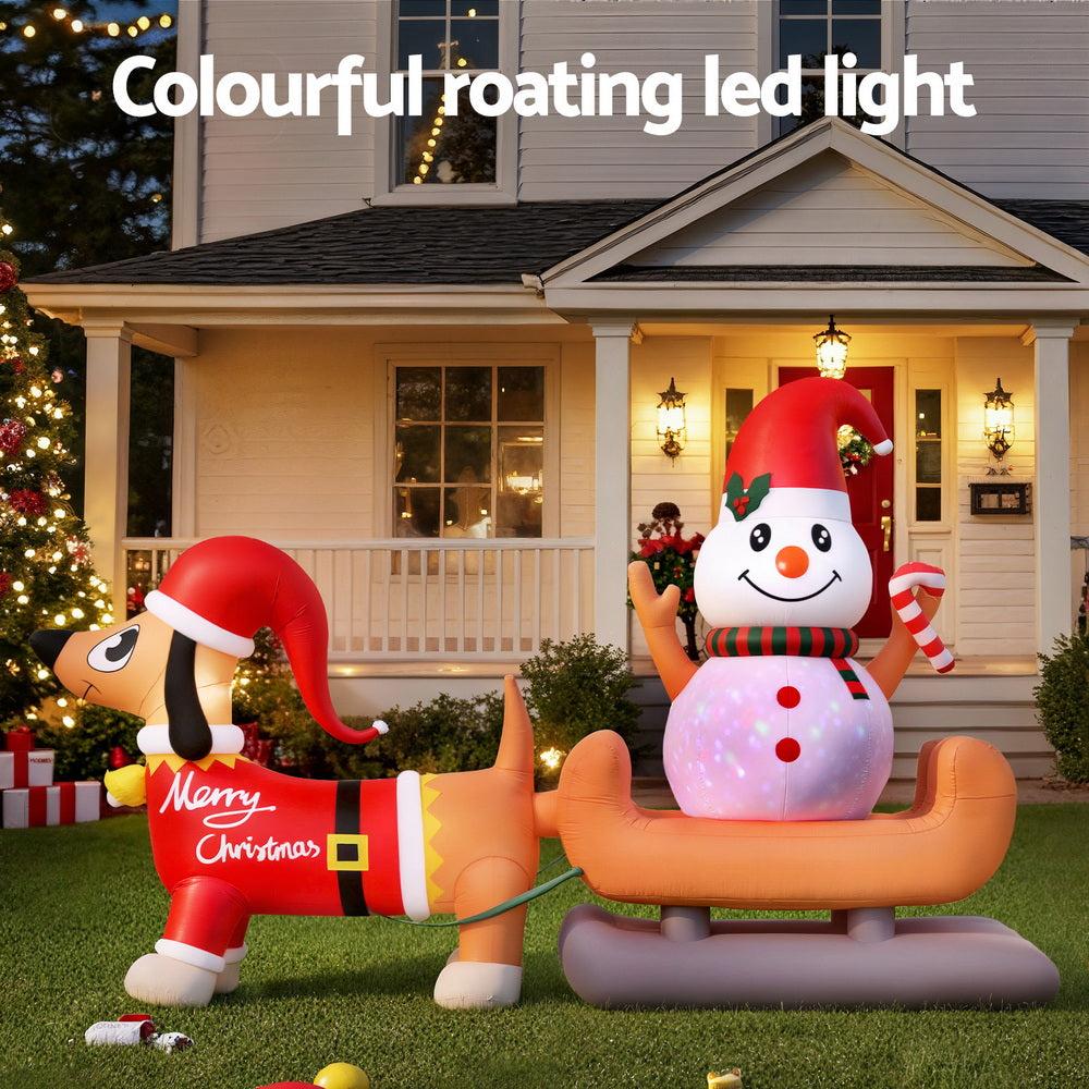 Inflatable dog and snowman yard decoration with glowing snowman and candy cane