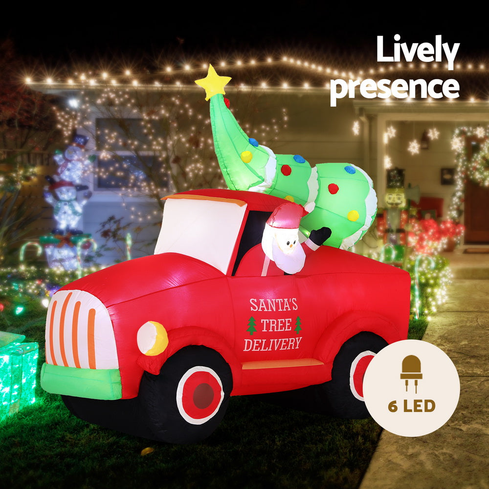 Inflatable red Santa tree delivery truck with green topper and glowing LED lights