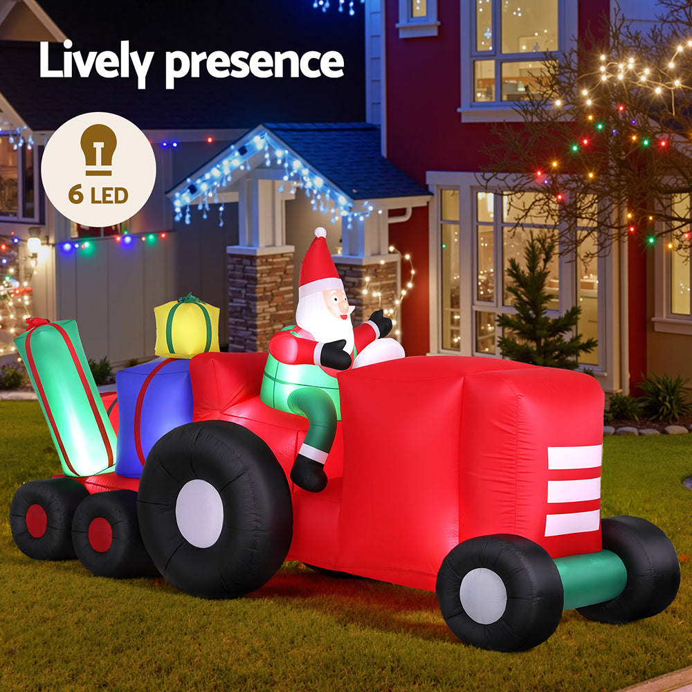 Inflatable Santa truck with red body, green base, black tires, and multiple LED lights