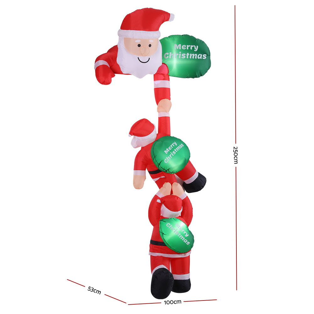 Inflatable climbing Santa figurine with green lit “Merry Christmas” balloons