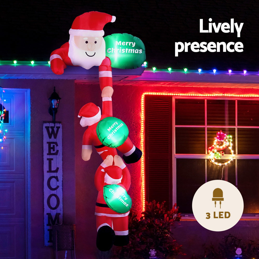 Inflatable climbing Santa with green “Merry Christmas” balloons and string LED lights