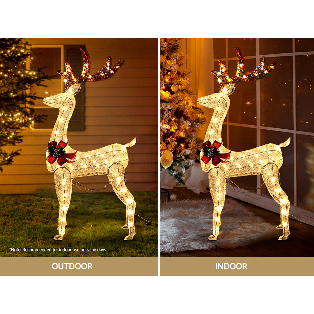 Lighted gold reindeer decoration with red bow and glowing LED outline, standing
