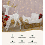 White glitter reindeer and sleigh LED display with red bow accents and warm string lights